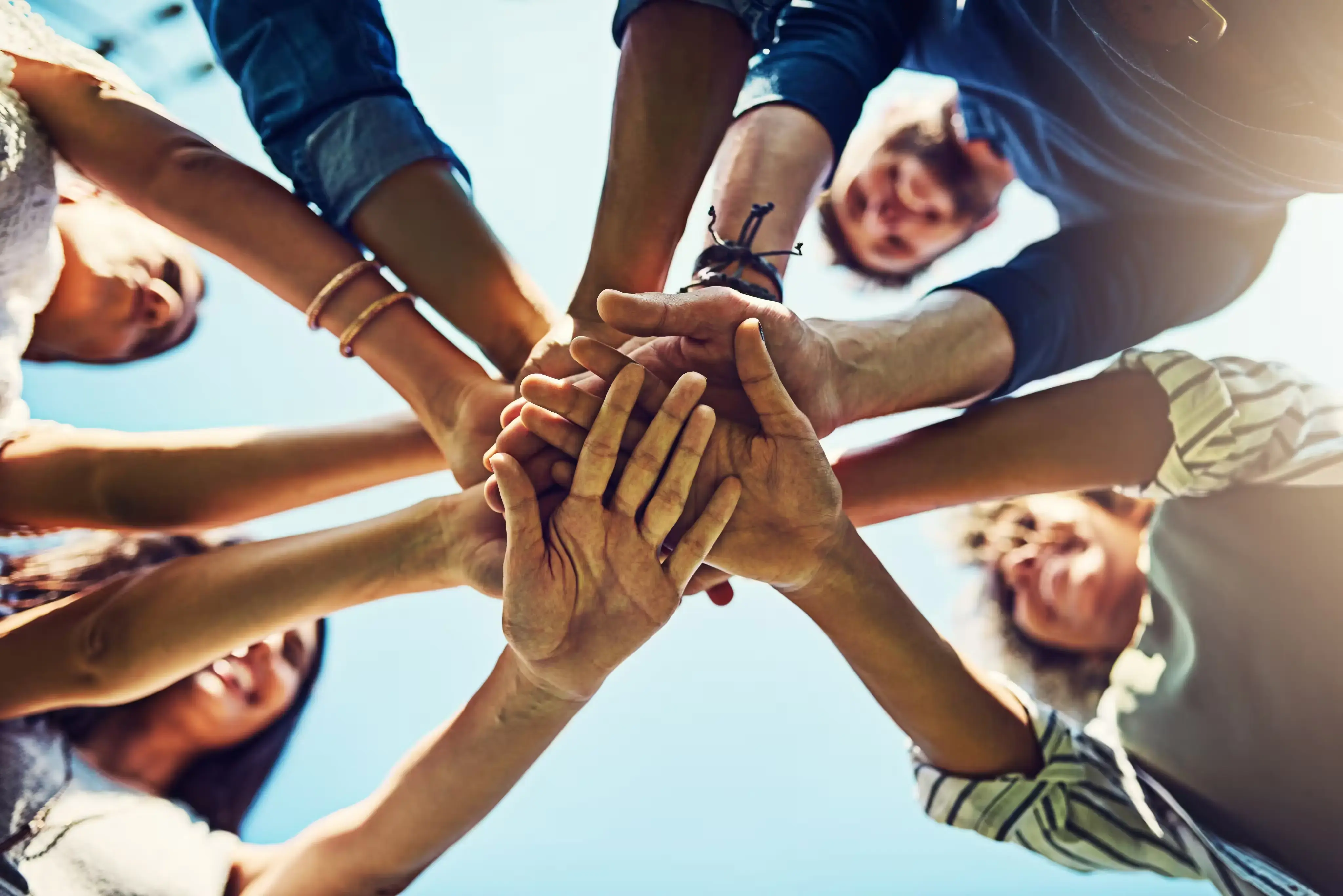 Several people placing their hands in a group